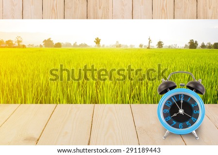 Blue alarm clock on table wood texture isolated on white background.
