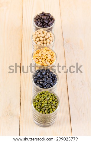 a lot of black bean, green beans, soybean, roasted coffee beans on wood background