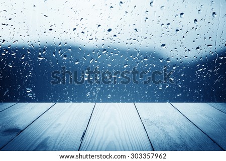 Blue filter - Abstract rain drops on a window or water drops on grass and wood background