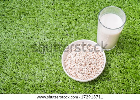 Job\'s tear in white ware and a glass of job\'s tear milk on grass