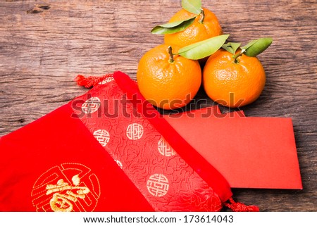 Chinese red pocket in Chinese red bag and mandarin orange on wooden table