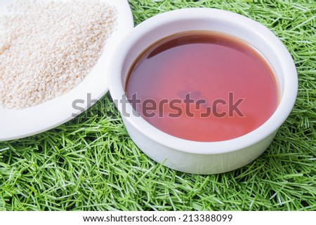 sesame oil seeds and sesame seeds on grass background