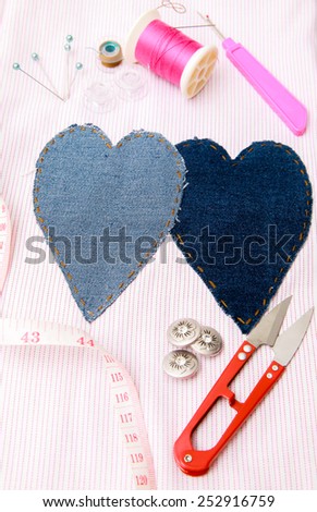 Set of crafts and needlework sewing stuff round two heart on fabric