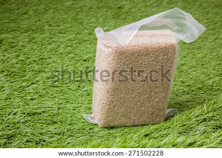 Jasmine brown rice in vacuum plastic bag package on green grass