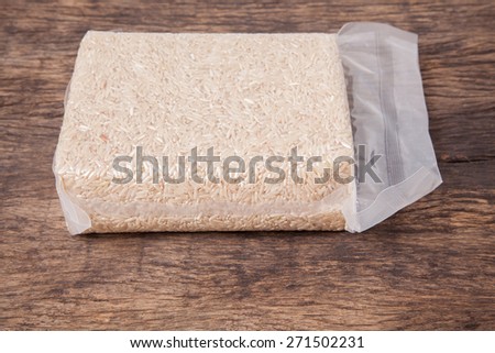 Jasmine brown rice in vacuum plastic bag package on wooden table top