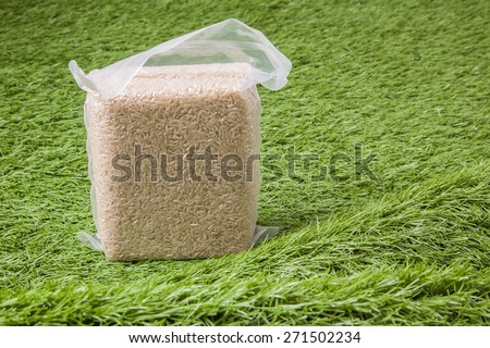 Jasmine brown rice in vacuum plastic bag package on green grass