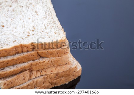 stack of slice whole wheat bread on black background
