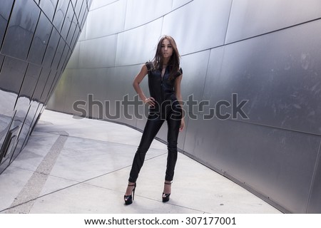 Very beautiful model in skin-tight dungarees. The leather suit is nice black color.  Profession model is very sexual and has dark tint skin.