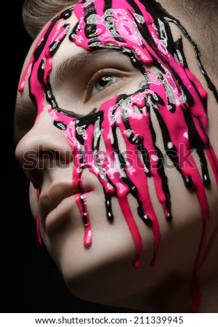 Portrait of a man poured pink and black paint on a black background