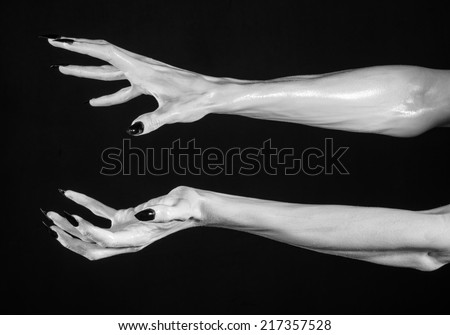 white hands of death with black nails, white death, the devil\'s hands, the hands of a demon, white skin, halloween theme, black background, isolated