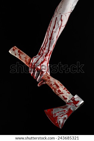 Bloody Halloween theme: bloody hand holding a bloody butcher\'s ax isolated on black background in studio