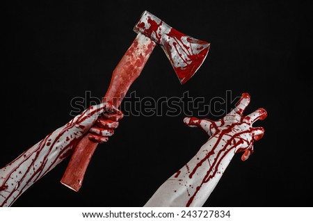 Bloody Halloween theme: bloody hand holding a bloody butcher\'s ax isolated on black background in studio