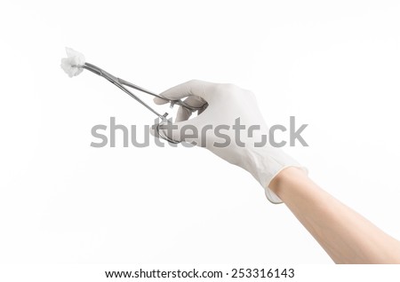 Surgery and medicine theme: doctor\'s hand in a white glove holding a surgical clamp with swab isolated on white background in studio
