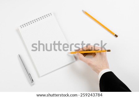 Business and reporter topic: Hand of a businessman holding a pencil to begin writing on a notepad