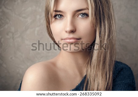 Dramatic portrait of a girl theme: portrait of a beautiful lonely girl isolated on a dark background in studio