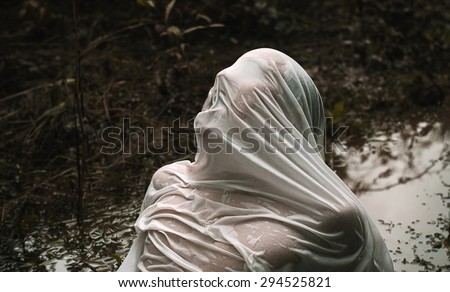 The abduction and Halloween theme: wrapped in a wet cloth person lying in the mud