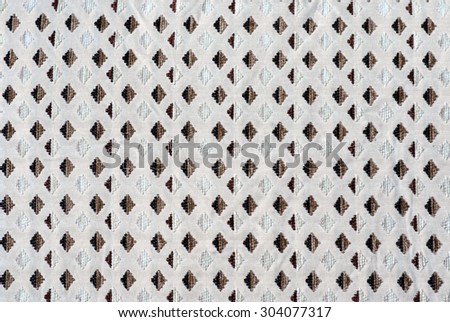 The texture of the fabric in the form of a brown diamond pattern is repeated on the white background