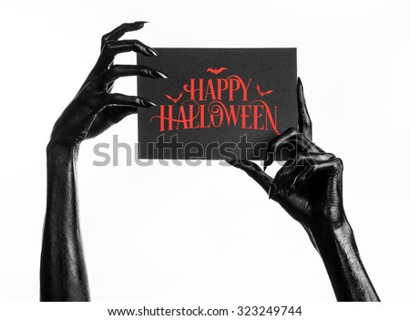 Postcard and Happy Halloween theme: black hand of death holding a paper card with the words Happy Halloween on a white isolated background in studio