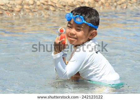 Japanese boy playing with water gun