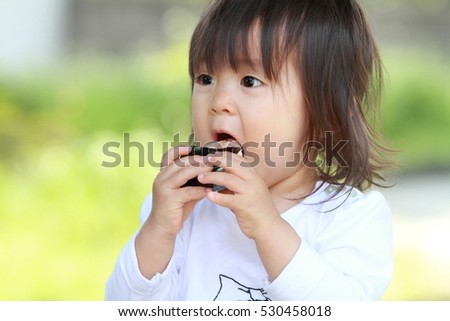 Japanese girl eating rice ball (1 year old)