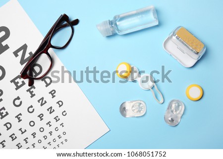 Flat lay composition with contact lenses, glasses and accessories on color background