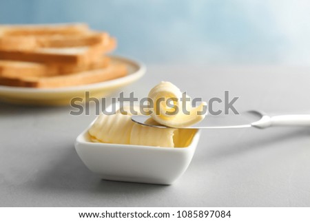 Knife and gravy boat with butter curls on table