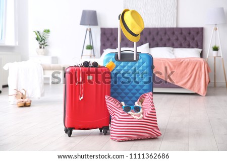Large suitcases and bag packed for summer journey in room