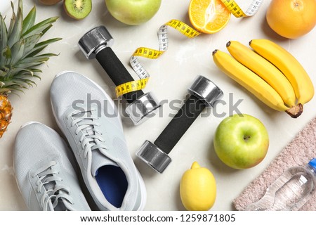 Flat lay composition with sport items and healthy food on grey background. Weight loss concept