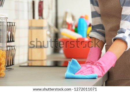 Woman cleaning kitchen counter with rag, closeup