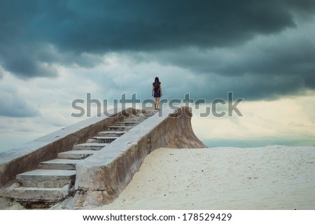 Stairs to nowhere; A female figure climbs a series of forgotten stone steps on a deserted beach; sense of isolation, depression, loneliness, hopelessness; Alternatively  hope after a 12-step program