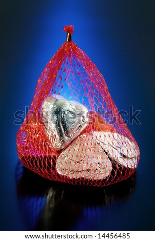 Foil wrapped Valentine hearts in red mesh bag.