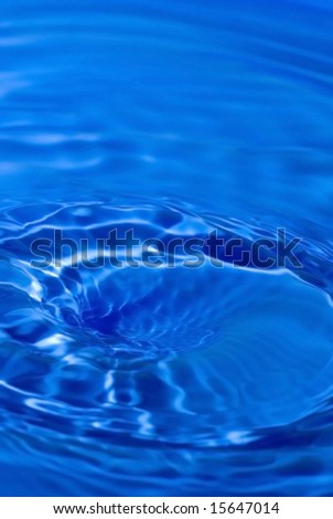 Abstract very deep blue of small water pool with swirls, waves, currents, shadows, and highlights. Good copyspace at top of image.