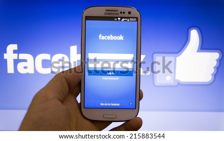08 September 2014 Istanbul, Turkey: Hand holding smartphone with Facebook social network mobile app with english interface