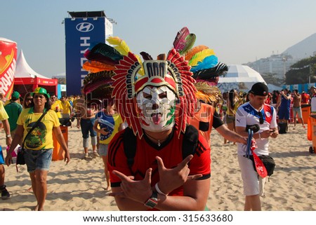 RIO DE JANEIRO, BRAZIL - JULY 17, 2014: Mexican soccer fans using mask celebrate in the arena FIFA fan fest during Brazil World Cup on Copacabana beach.