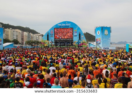 RIO DE JANEIRO, BRAZIL - JULY 13, 2014: Soccer fans celebrate in the arena FIFA fan fest during Brazil World Cup on Copacabana beach.