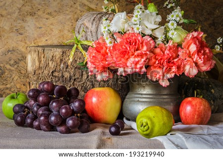 Still life with Fruits were placed together with a vase of flowers beautifully.