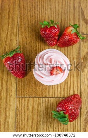 Strawberry cupcakes with fresh strawberries  on a table top.