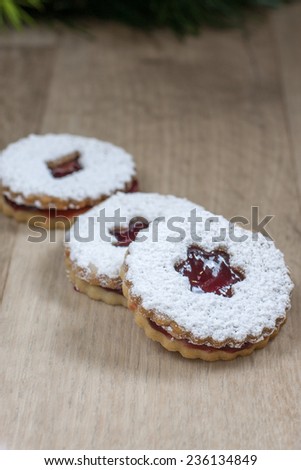 Raspberry Linzer cookies on a wooden work bench.