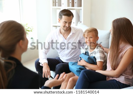 Young couple and their son meeting with headmistress at school