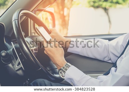 Hand using phone sending a text while driving to work ,businessman ,vintage color tone