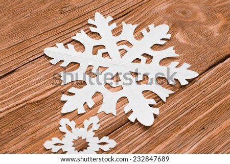 White decorative  paper christmas snowflake on a wood background. happy new year card. new year background
