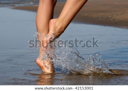 Nice legs of a pretty girl walking in water