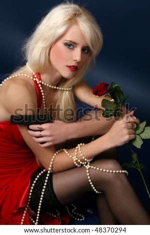 beautiful young blonde woman in red dress with gun