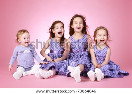 four Happy young girl in violet dress laugh on pink background