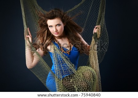 Beautiful girl in fishnet on dark-blue background