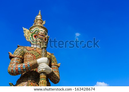 The statue of giant hold club and blue sky in Wat Phra Kaew ,Thailand