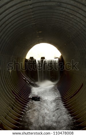 Water flowing from a dam theough a large pipe