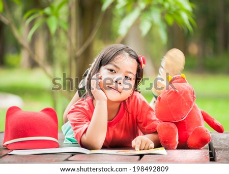 Asian girl reading a book in the autumn garden