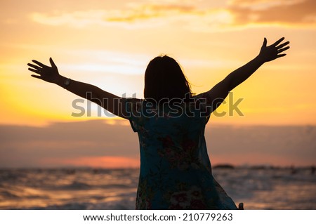 Young lady dances alone at the tropical beach, sunset
