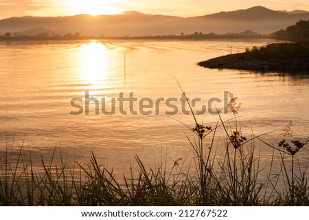 Sunrise morning landscape with lake in a mountain forest. The first rays of the sun in the trees.